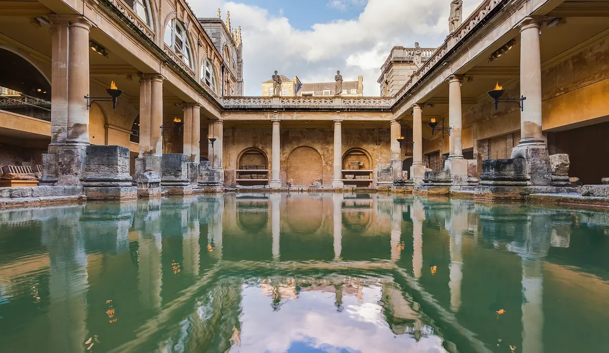 La grande vasca dei Roman Baths di Bath con il colonnato riflesso nell’acqua